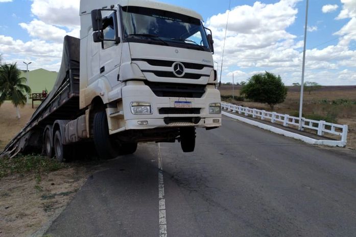 Caminhão perdeu tração, saiu da pista e ficou pendurado em ponte