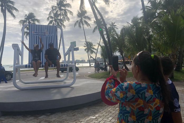 Turistas e a cadeira gigante na Ponta Verde