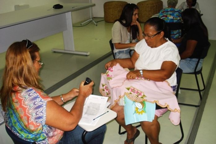 Professora Jô Cabral ajuda artesã no preenchimento s FICH funcional