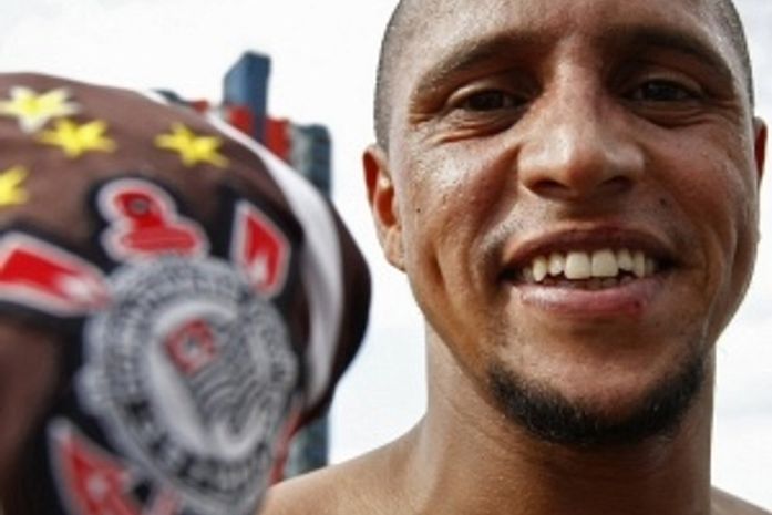 Principal reforço de 2010, Roberto Carlos segura camisa do Corinthians, onde reencontrará Ronaldo