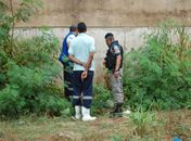 Sargento e funcionários do IML observam o corpo