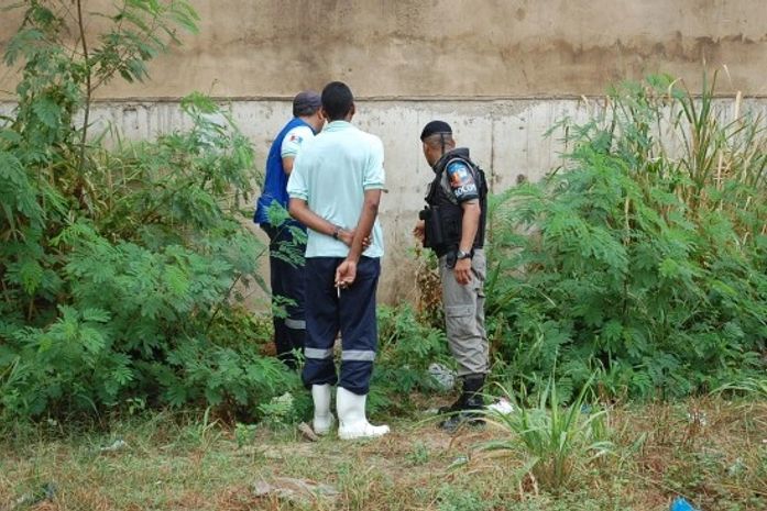 Sargento e funcionários do IML observam o corpo