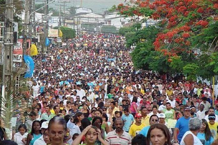 As pessoas acompanham a procissão a pé, montadas a cavalo, de bicicletas, carros, motos, caminhões e carroças