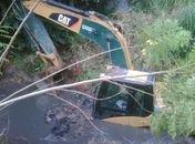 Retroescavadeira cai em córrego em SP