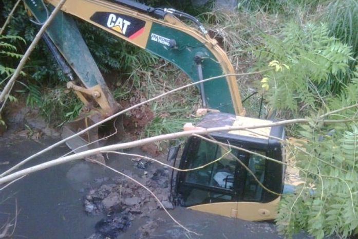 Retroescavadeira cai em córrego em SP