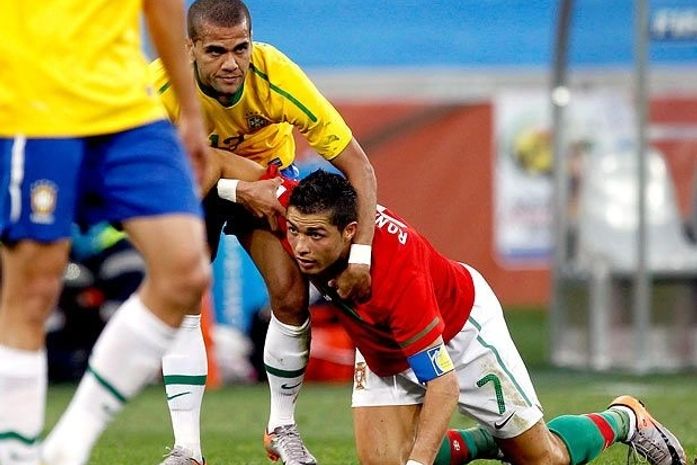 Cristiano Ronaldo fica no chão e Daniel Alves auxilia o português a se levantar