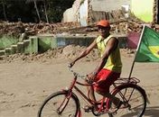 Em Alagoas, torcedor passa de bicicleta em frente à rua destruída completamente destruída
