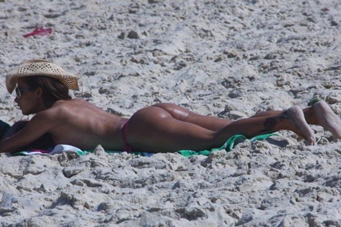 Lucilene Caetano toma sol sem a parte de cima do biquíni