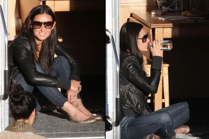 Descontraída, Demi Moore aparece sentada no chão nos bastidores