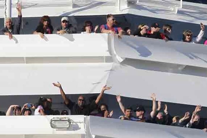 Passageiros acenam à medida que o Carnival Splendor se aproxima do porto de San Diego, na Califórnia, nesta quinta-feira (11).