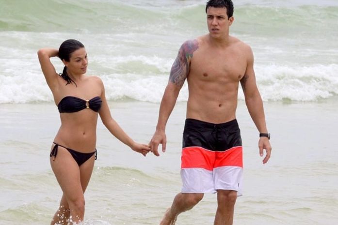 Isis Valverde curte praia e ganha colinho do namorado no mar