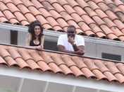 Amy chega a hotel no Rio com seguranças e sorri da sacada