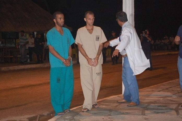 Acusados durante a reconstituição do crime