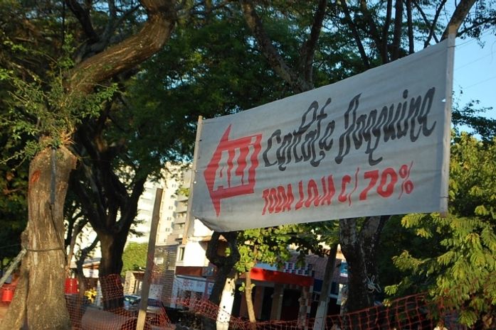 Proprietária colocou uma faixa no canteiro central para mostrar que ainda estão funcionando