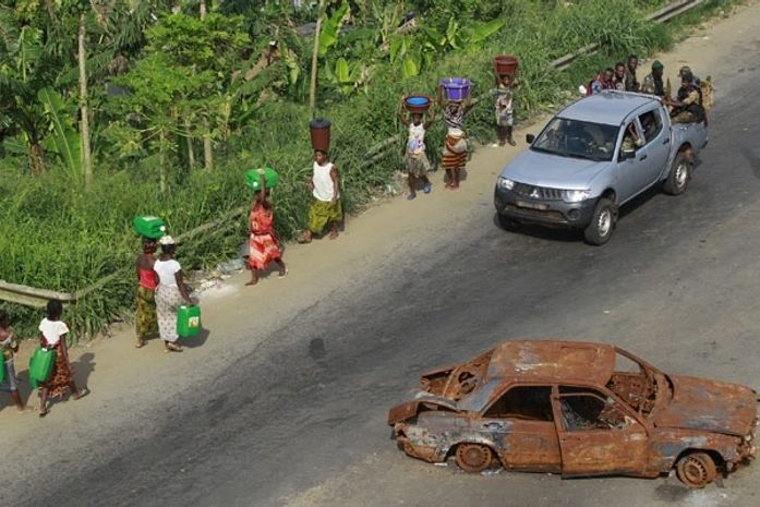 Forças leais a Alassane Ouattara se reunem em região onde mulheres carregam água, em Abidjan