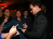 Bono Vox atende fãs em porta de restaurante