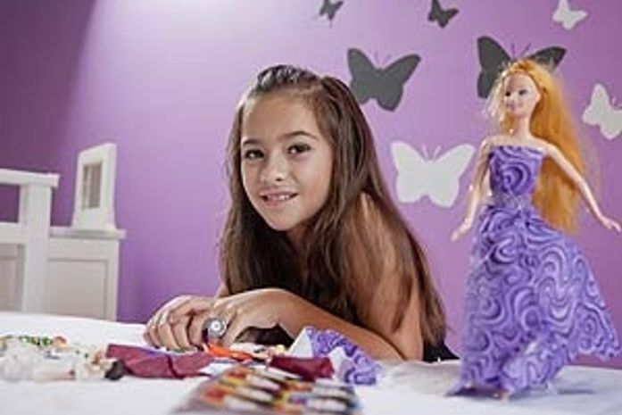 Menina de nove anos cria roupas para bonecas com tecido e guardanapo