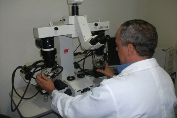 Perito utiliza um comparador balístico no Insituto de Criminalística