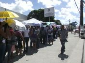 Diversas pessoas esperavam as fichas na fila 
