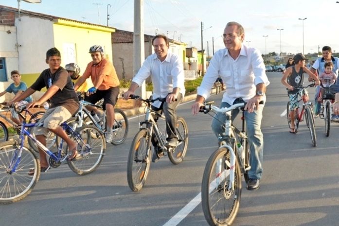 Luciano Barbosa e Renan Calheiros caminhando de bicicletas nas ruas de Arapiraca