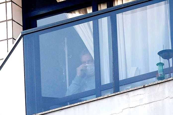 Lula aparece na janela de casa com máscara e medicação