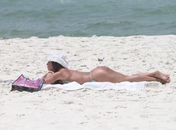 Suposto affair de Neymar curte praia no Rio e faz topless