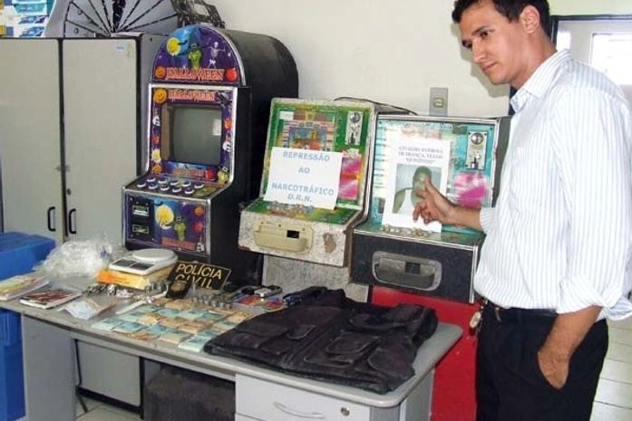 Delegado Ronilson, à época, mostrando material recolhido na casa de Quinzinho