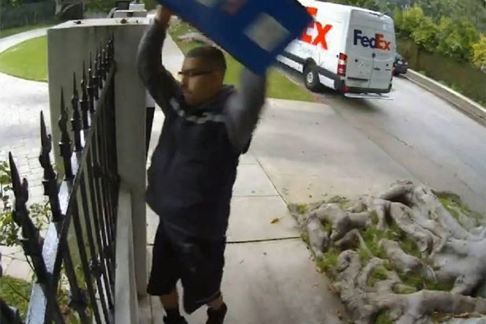 Funcionário foi filmado jogando a mercadoria de um cliente por cima da cerca.