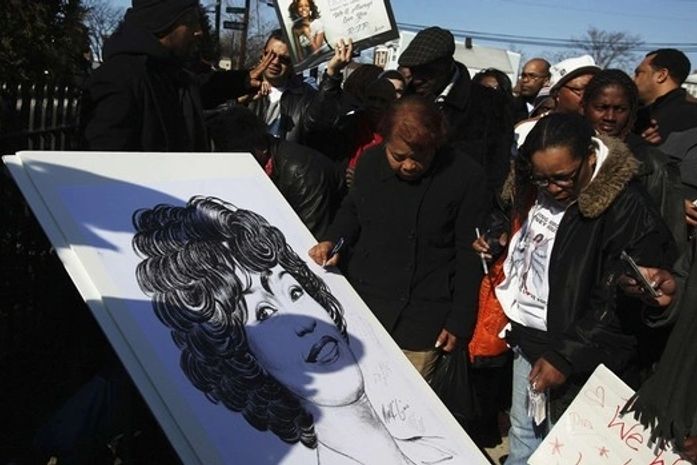Fãs assinam cartaz com imagem de Whitney Houston nas proximidades da Igreja Batista New Hope )