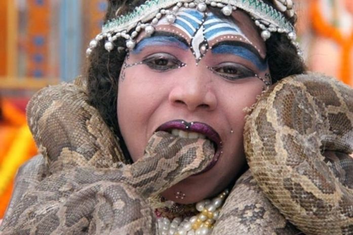 Adolescente põe cobra na boca.