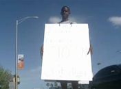 Como castigo, estudante foi obrigado a ficar parado com um cartaz pendurado no pescoço em cruzamento em Miami. 