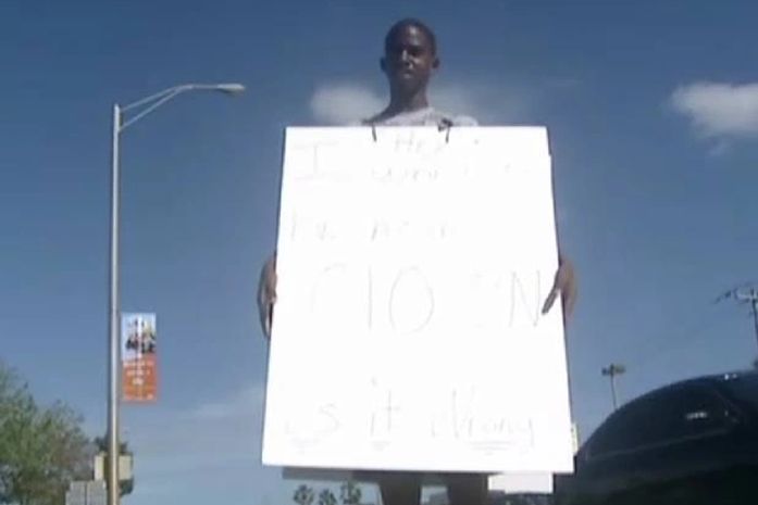 Como castigo, estudante foi obrigado a ficar parado com um cartaz pendurado no pescoço em cruzamento em Miami.