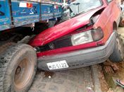 Gol ficou imprensado entre poste e caminhão