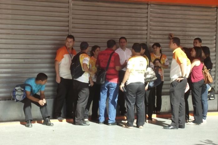 Funicionários esperam na porta das lojas
