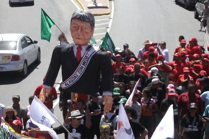 Boneco do governador é levado por trabalhadores