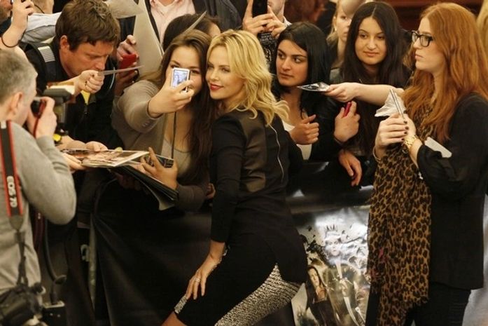 Charlize Theron posa para fotos com fãs na Alemanha