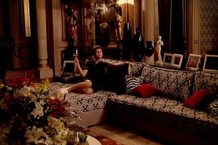 Com pose de madame, Nina se acomoda no sofá de Carminha