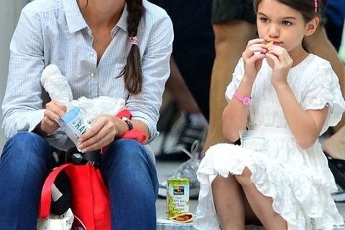 Zero glamour: Katie Holmes e Suri comem biscoito em escada de museu