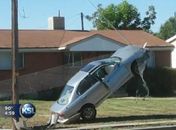 Motorista ficou com o carro pendurado após atingir um cabo. 