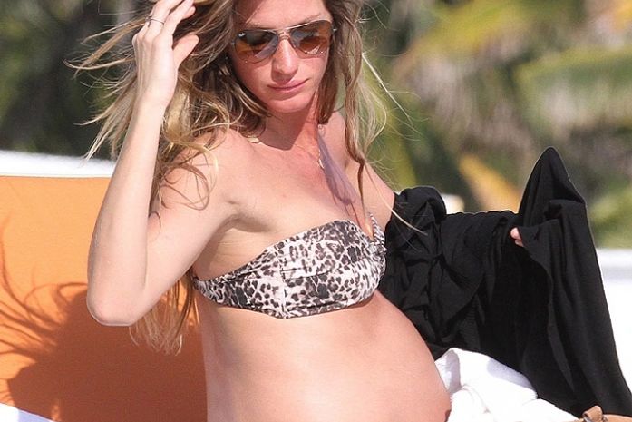 Gisele Bündchen exibe o barrigão de grávida na praia