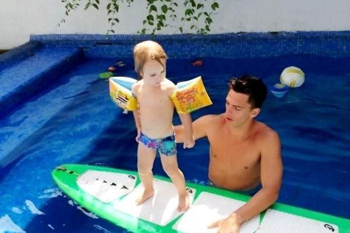 Namorado de Danielle Winits dá aula de 'surf' para o caçula da atriz