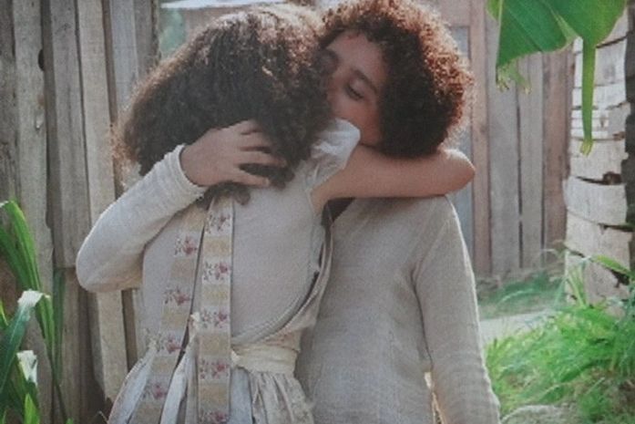 Antes de fugir do morro, Elias ganha caixa de engraxate e se despede de Madá