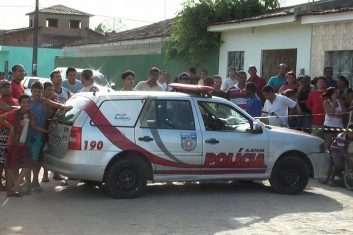 Curiosos observam local do assassinato onde ocorreu o crime