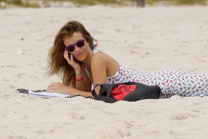 Juliana Didone aproveita tempo livre e estuda na praia