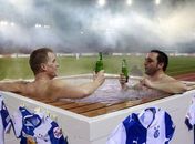 Torcedores assistem à partida em jacuzzi na beira do campo na Suíça