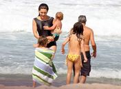 Com maiô comportado, Claudia Abreu mostra boa forma em praia em família