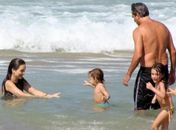 Claudia Abreu e a família aproveitam dia de praia no Leblon, no Rio