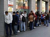 jovens espanhóis encaram filas para entrar em uma agência de  trabalho