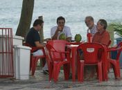 Rodrigo Lombardi toma água de coco em praia