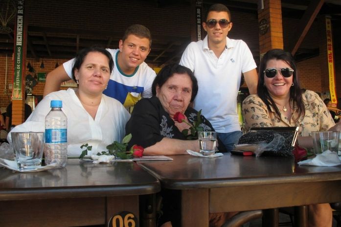 Dona Ivanilda com a rosa vermelha na mão entre seus familiares